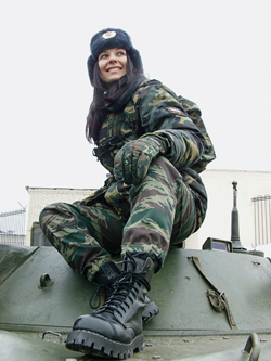 Участница RIDEBOOK в камуфляжной форме сидит на танке